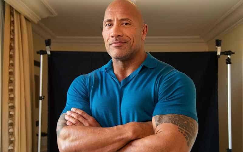 Dwayne "the Rock" Johnson wearing a blue shirt with his arms folded